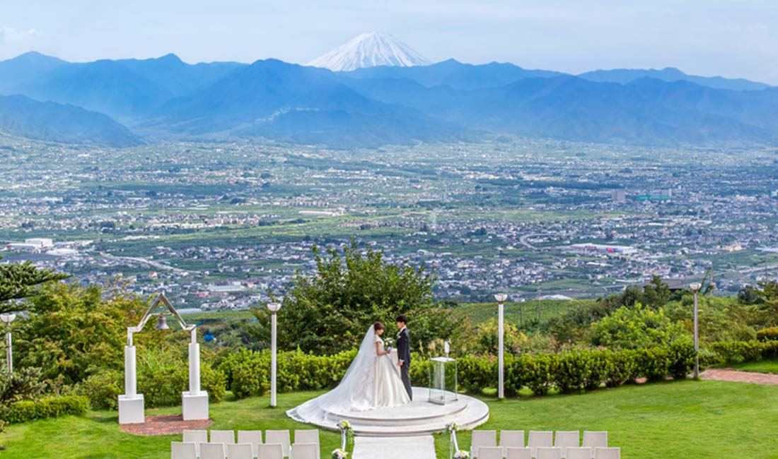 標高555メートルの高台から眺める緑と青い空に囲まれた開放感抜群のガーデン挙式が叶う結婚式場。パーティ会場は6つあり、ゲスト人数やお好みのテイストに合わせて選択できます。宿泊部屋は全室から世界遺産の富士山と新日本三大夜景が臨めるため、遠方からのゲストさまにも喜ばれます。